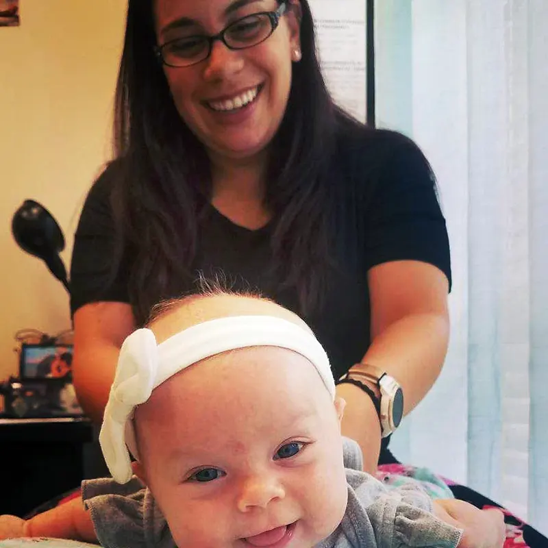 Chiropractor Dr. Carrie Cunningham of Mother Goose Chiropractic in Bonita Springs, FL Performing Child Chiropractic Adjustment.