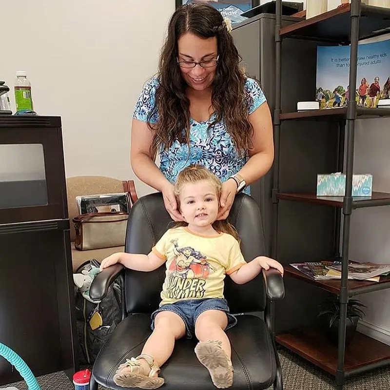 Chiropractor Dr. Carrie Cunningham of Mother Goose Chiropractic in Bonita Springs, FL Performing Child Chiropractic Adjustment.